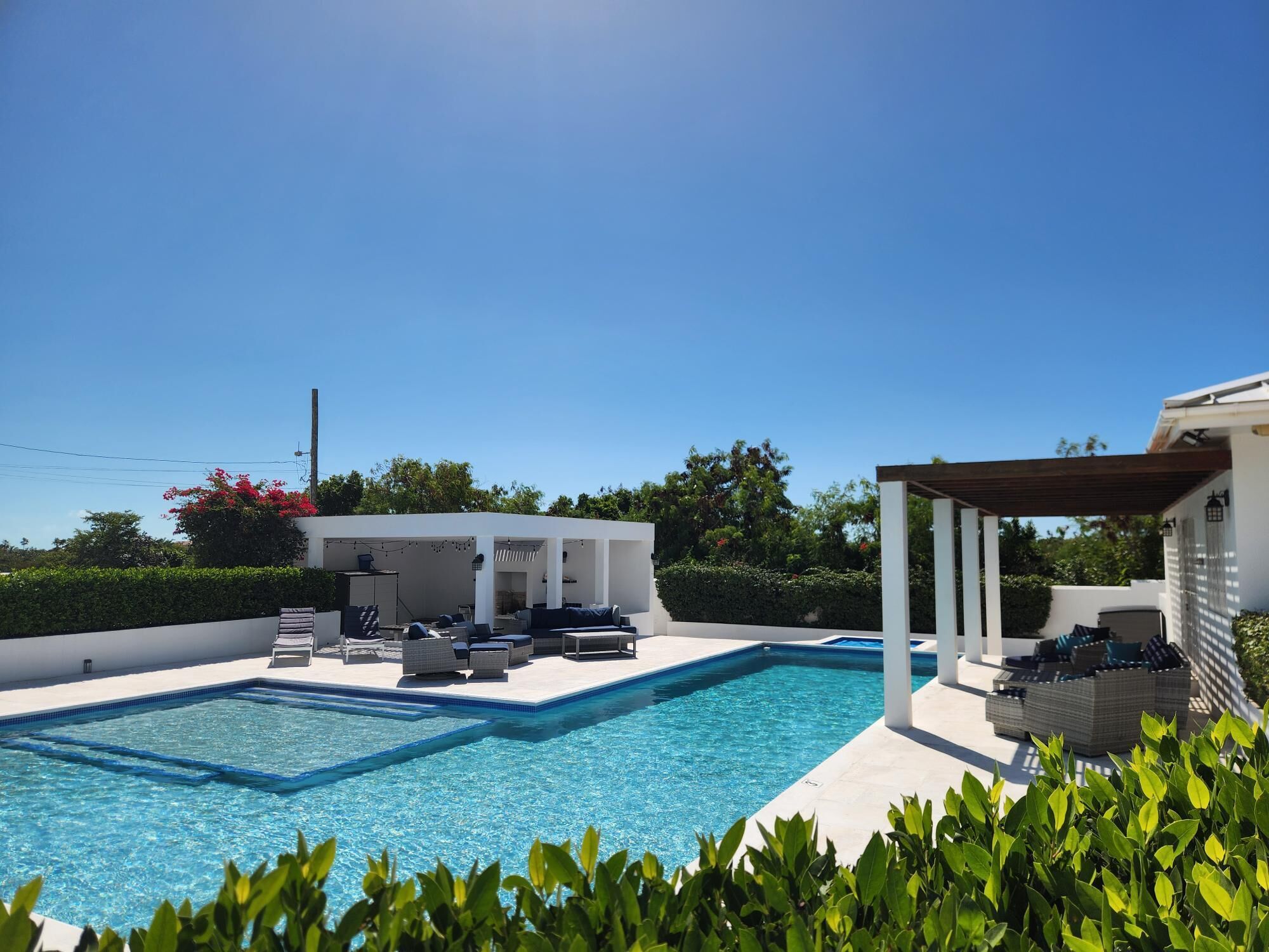 The pool and a covered seating area in daylight.