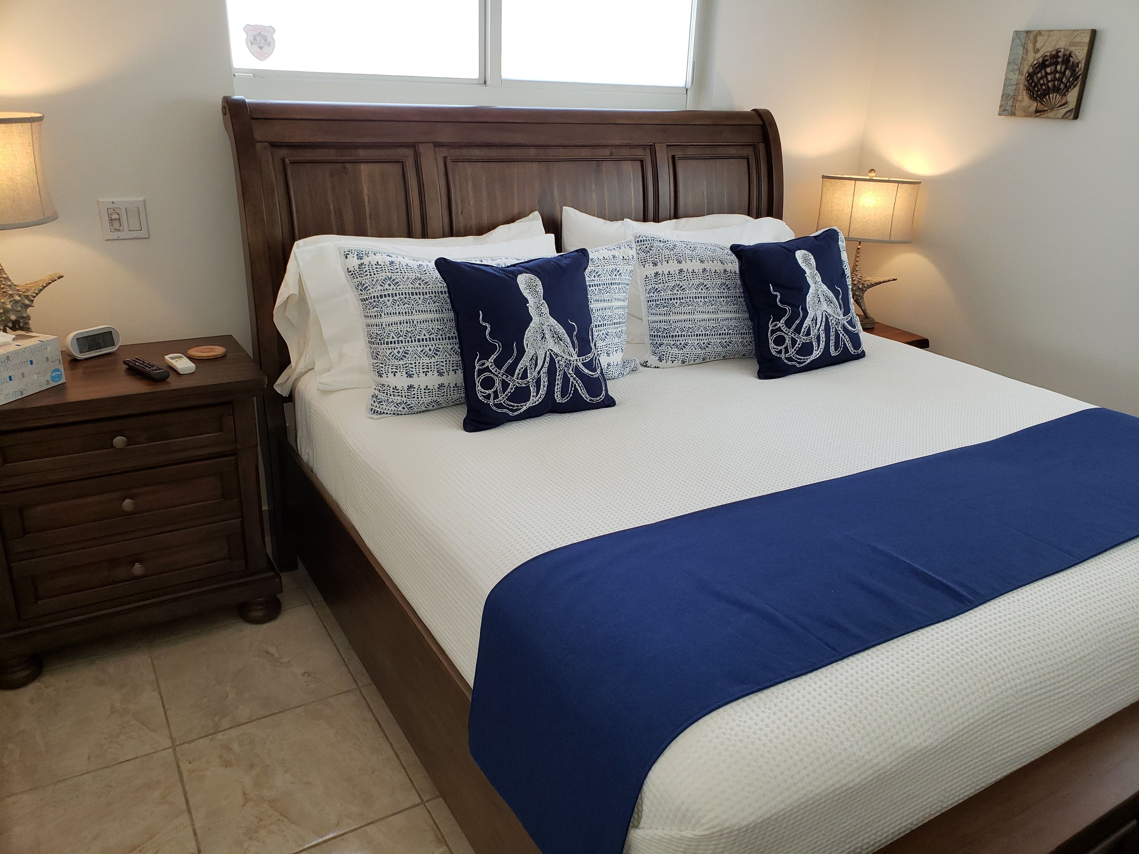 A bedroom with a wood bed and a blue bed runner.
