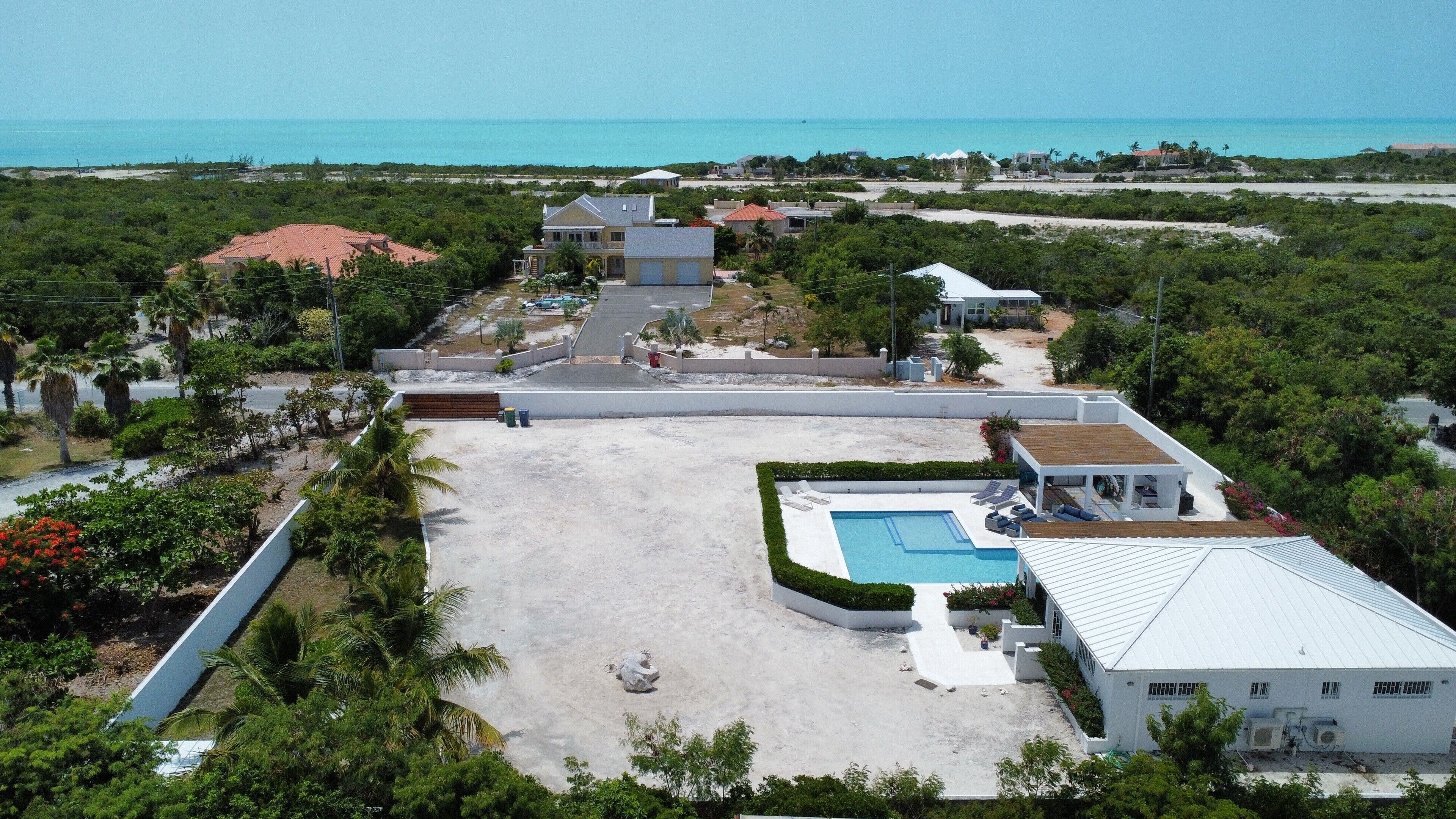 An aerial view of the villa, the pool, and the sea.