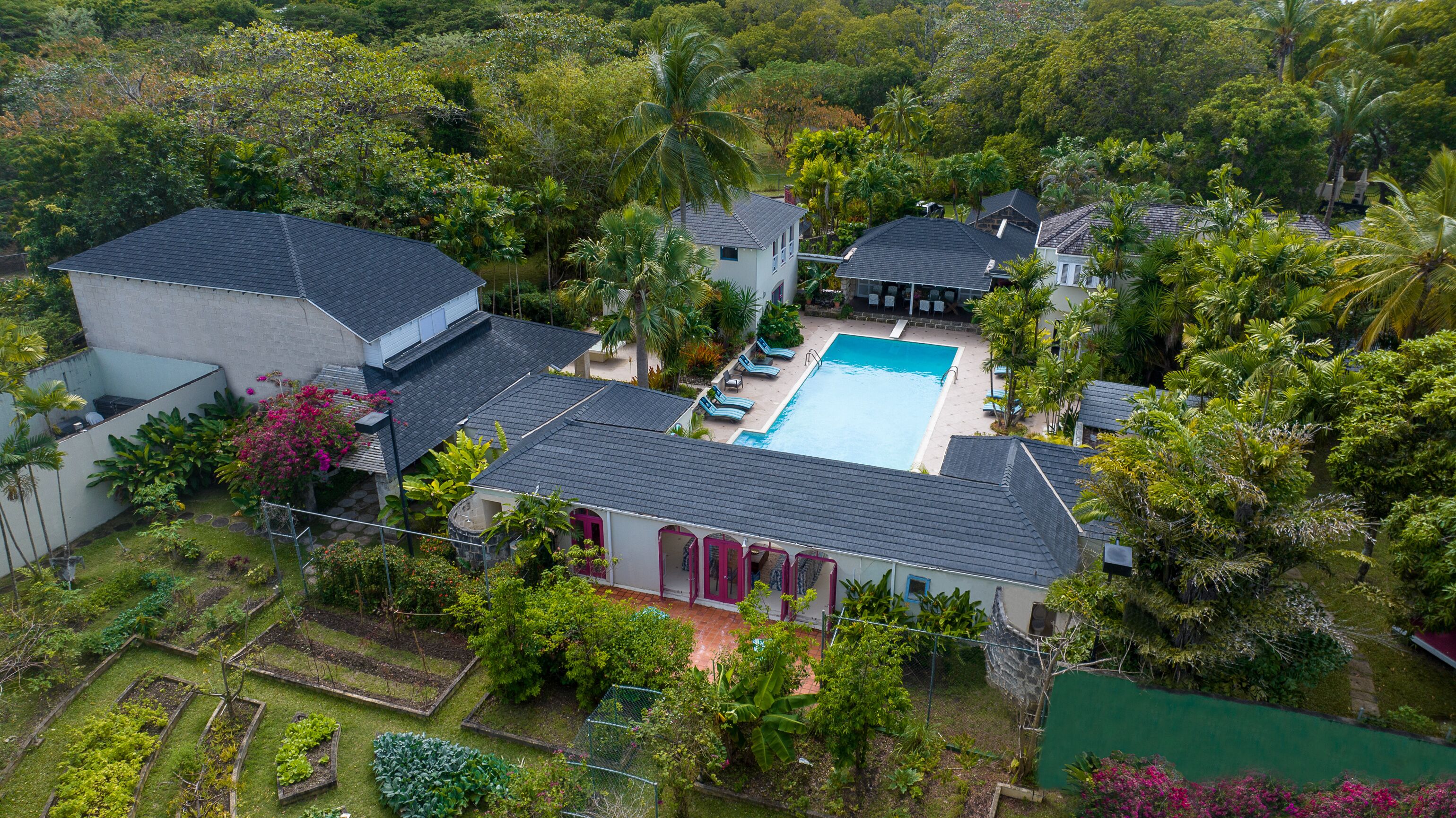 An aerial view of the estate buildings, the pool, and the gardens.