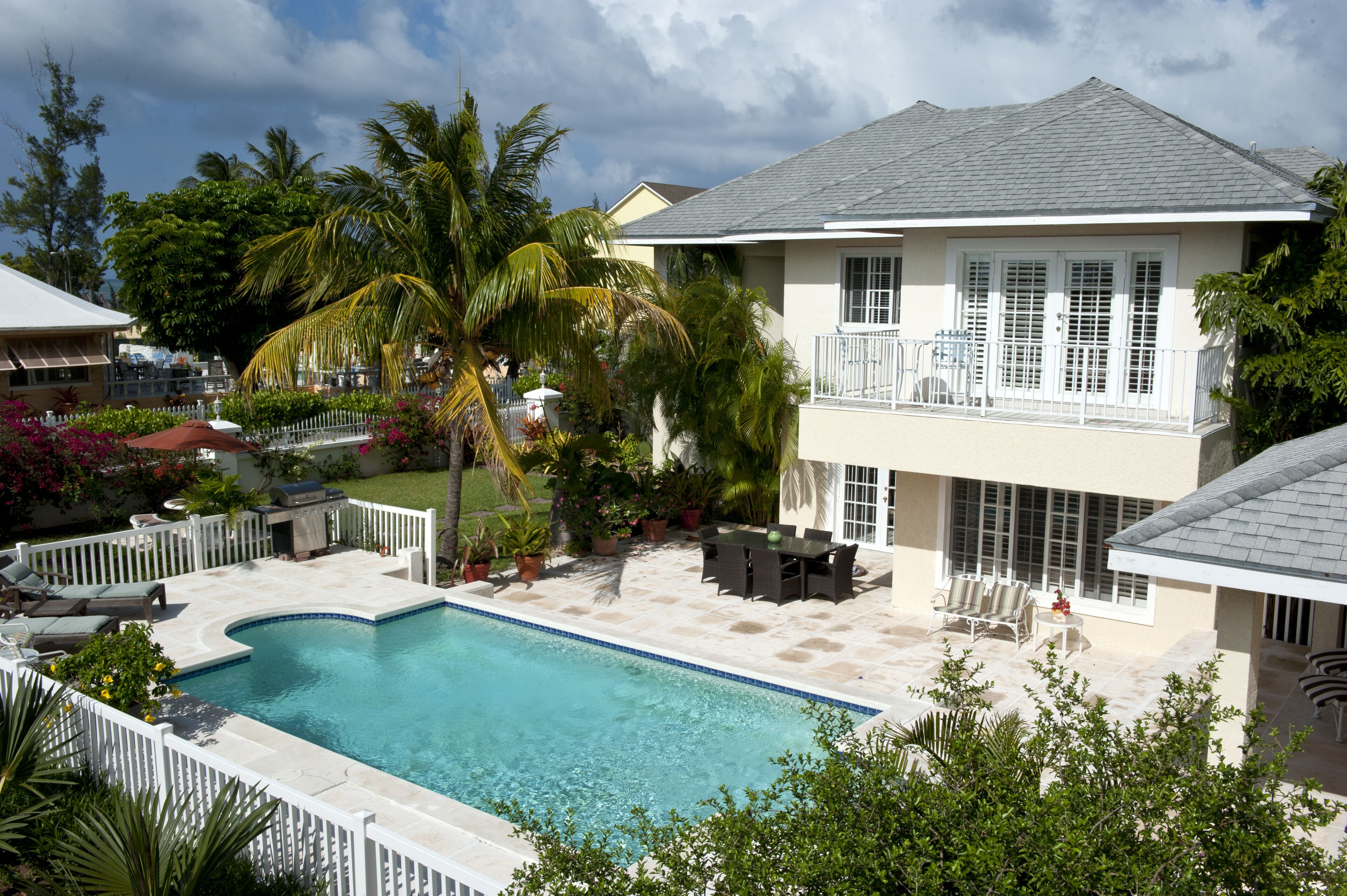 The pool, the patio, and the house in daylight.