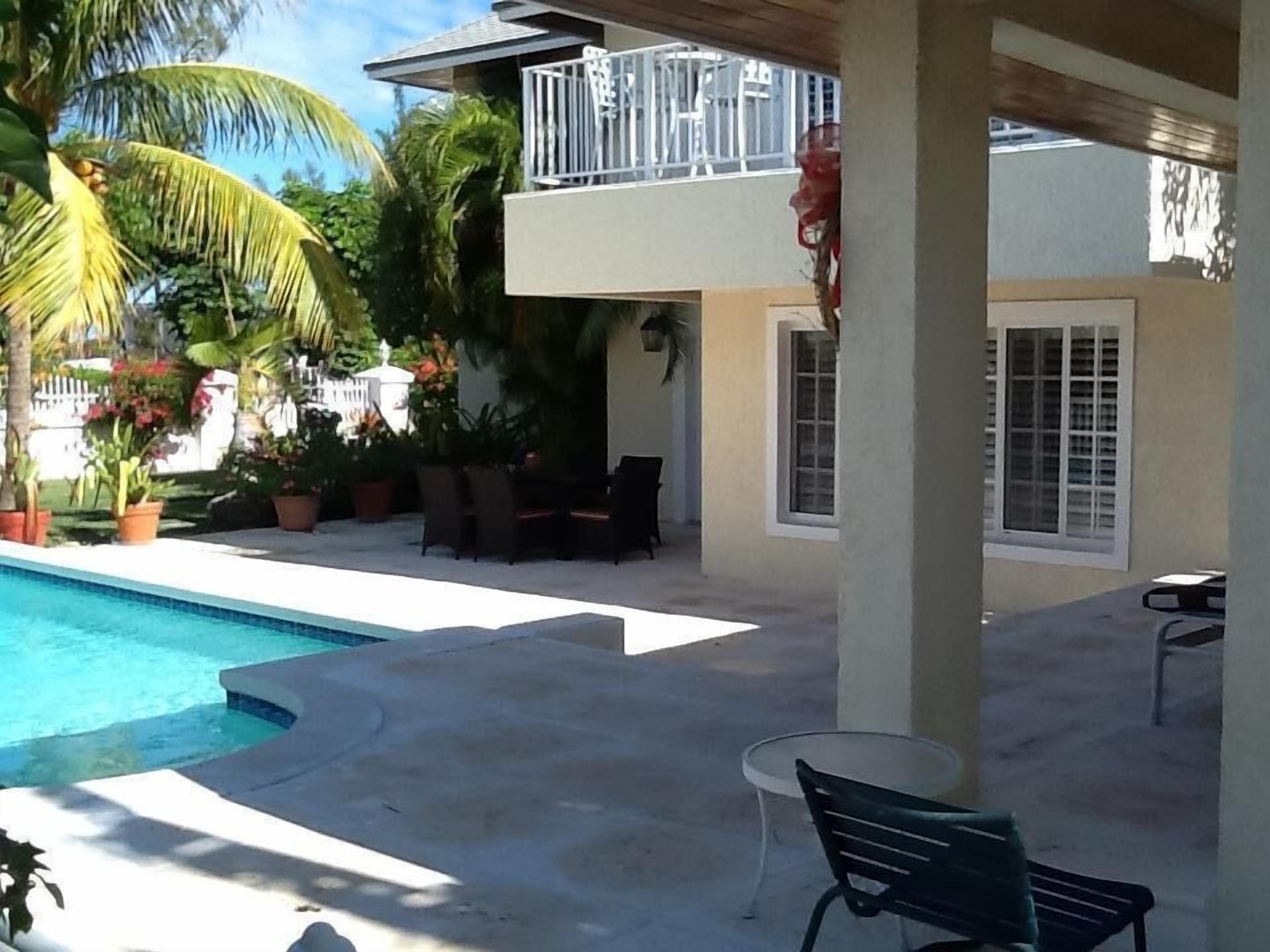 The pool beside the covered patio in daylight.