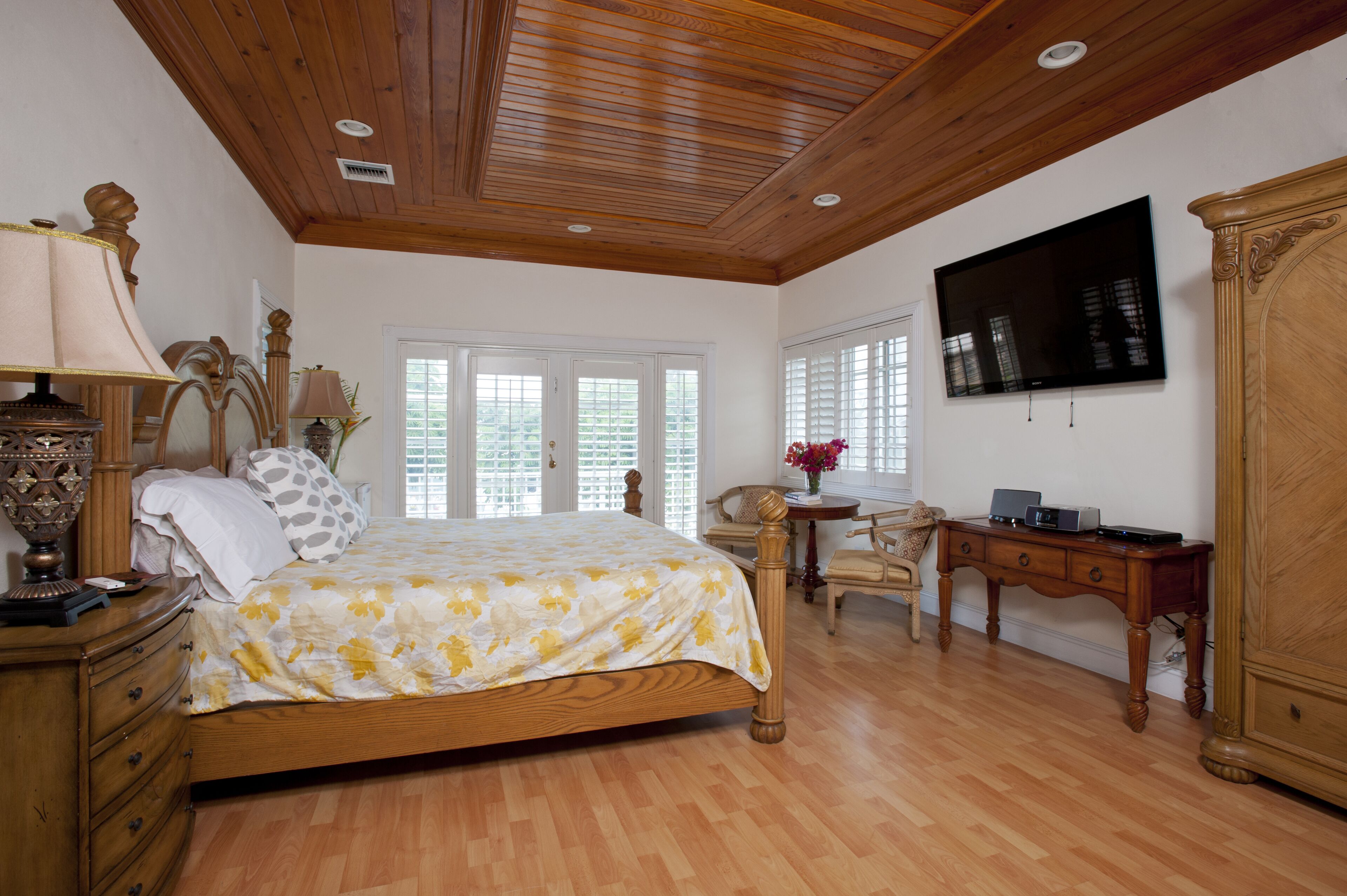 A bedroom with a double bed and a wall television.