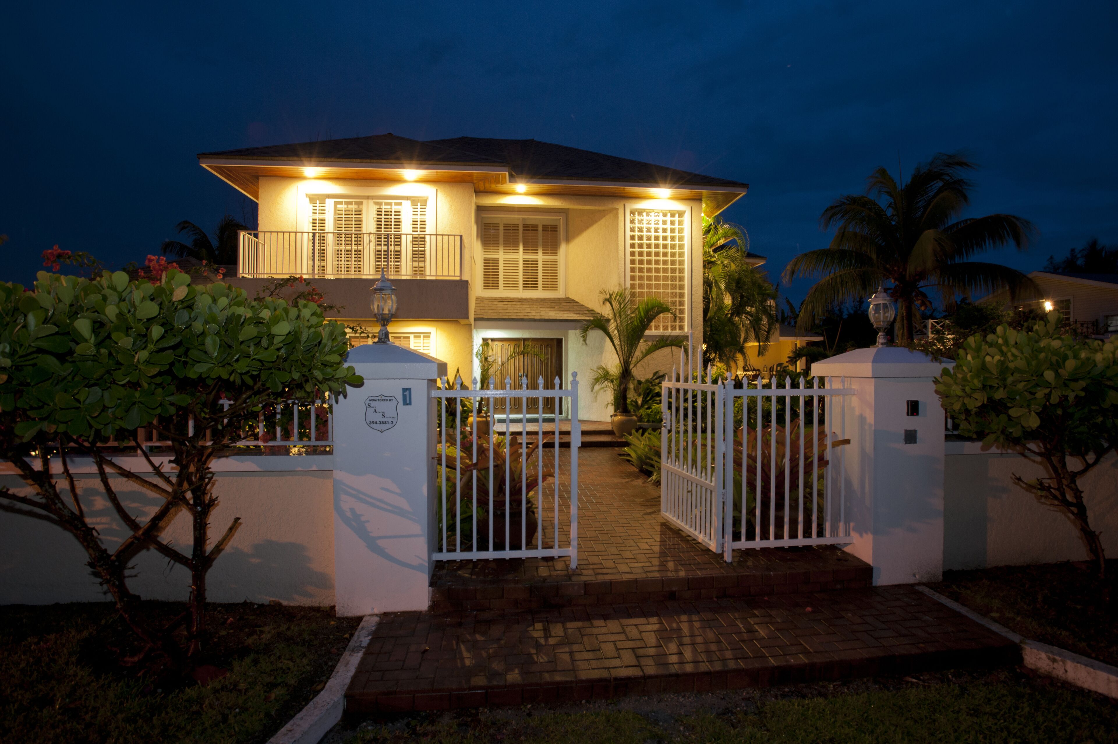 The front gate and the house at night.
