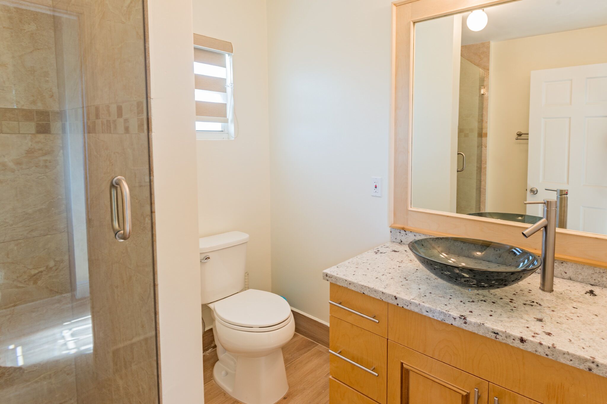 A bathroom with a shower, a toilet, and a sink.
