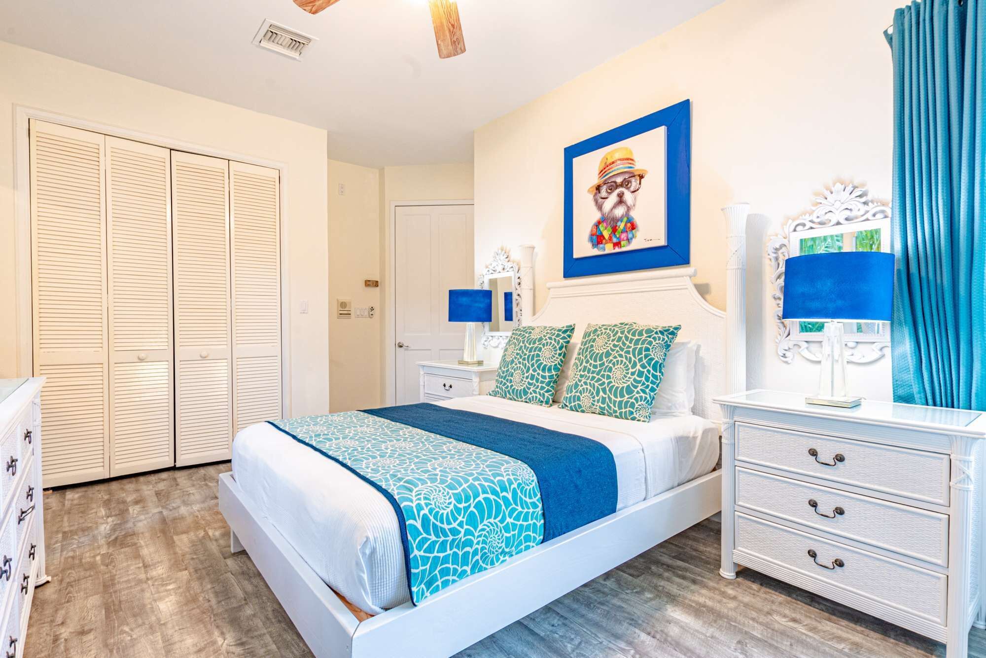 A bedroom with a bed and blue pillows.