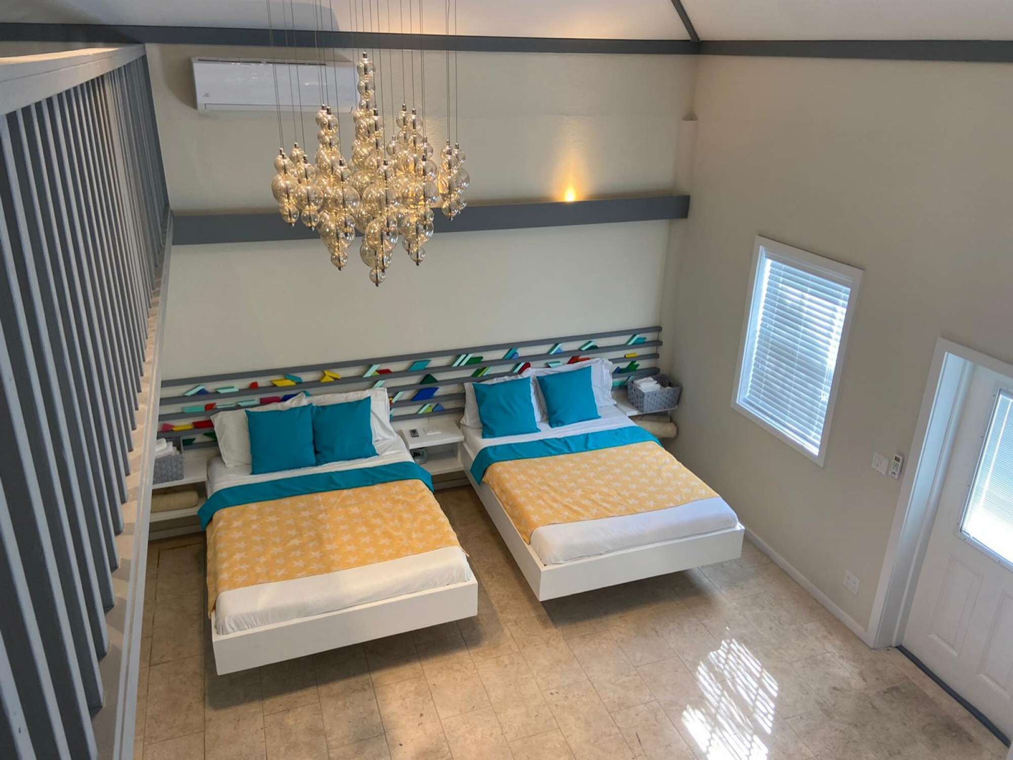 Two beds and a chandelier, seen from the loft.