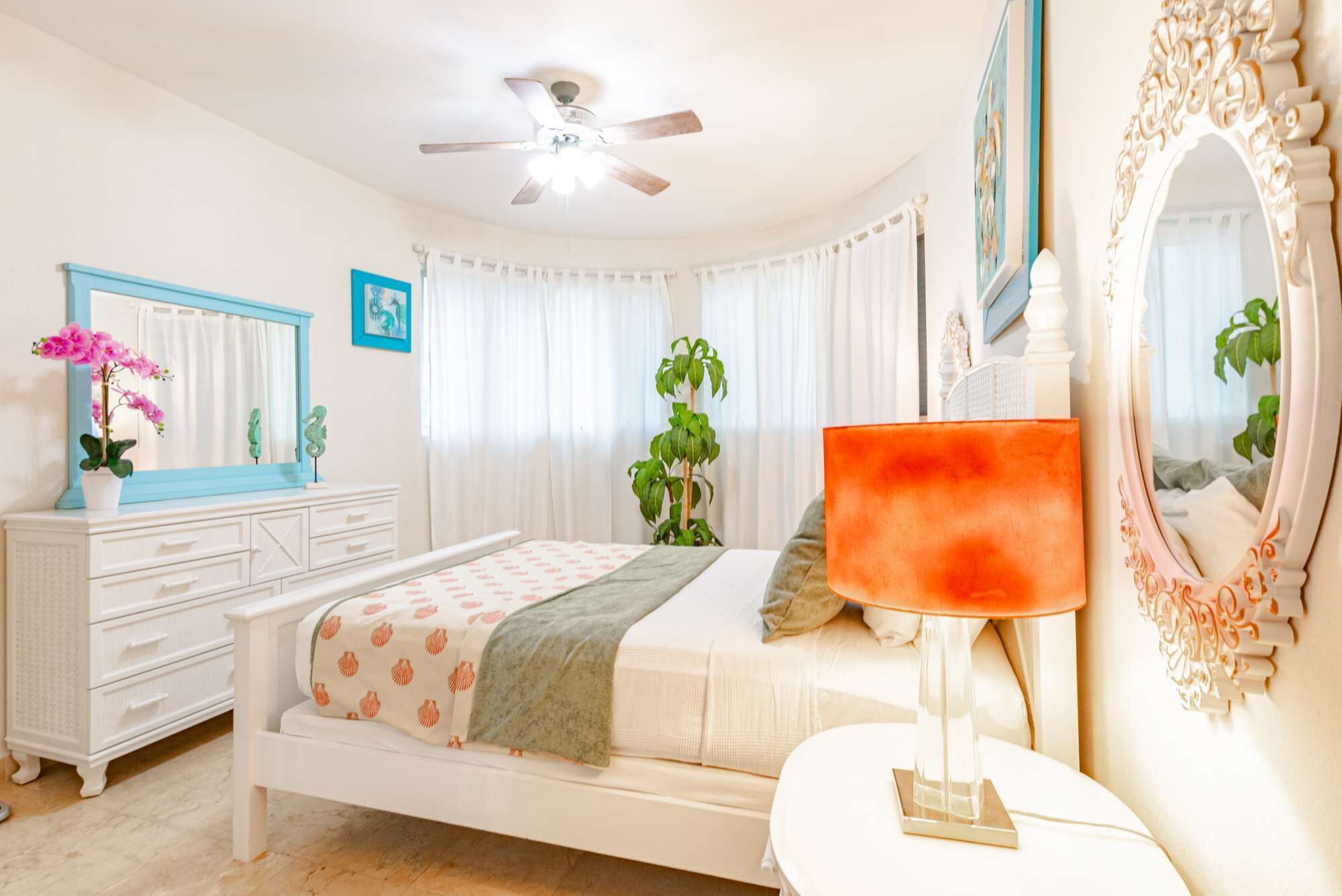 A bedroom with a bed and a white dresser.