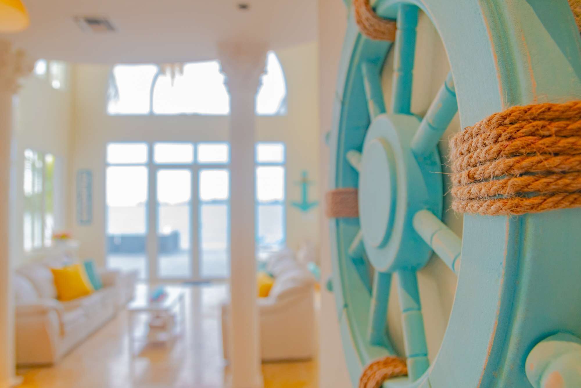 A ship wheel decoration at the entry to the living room.