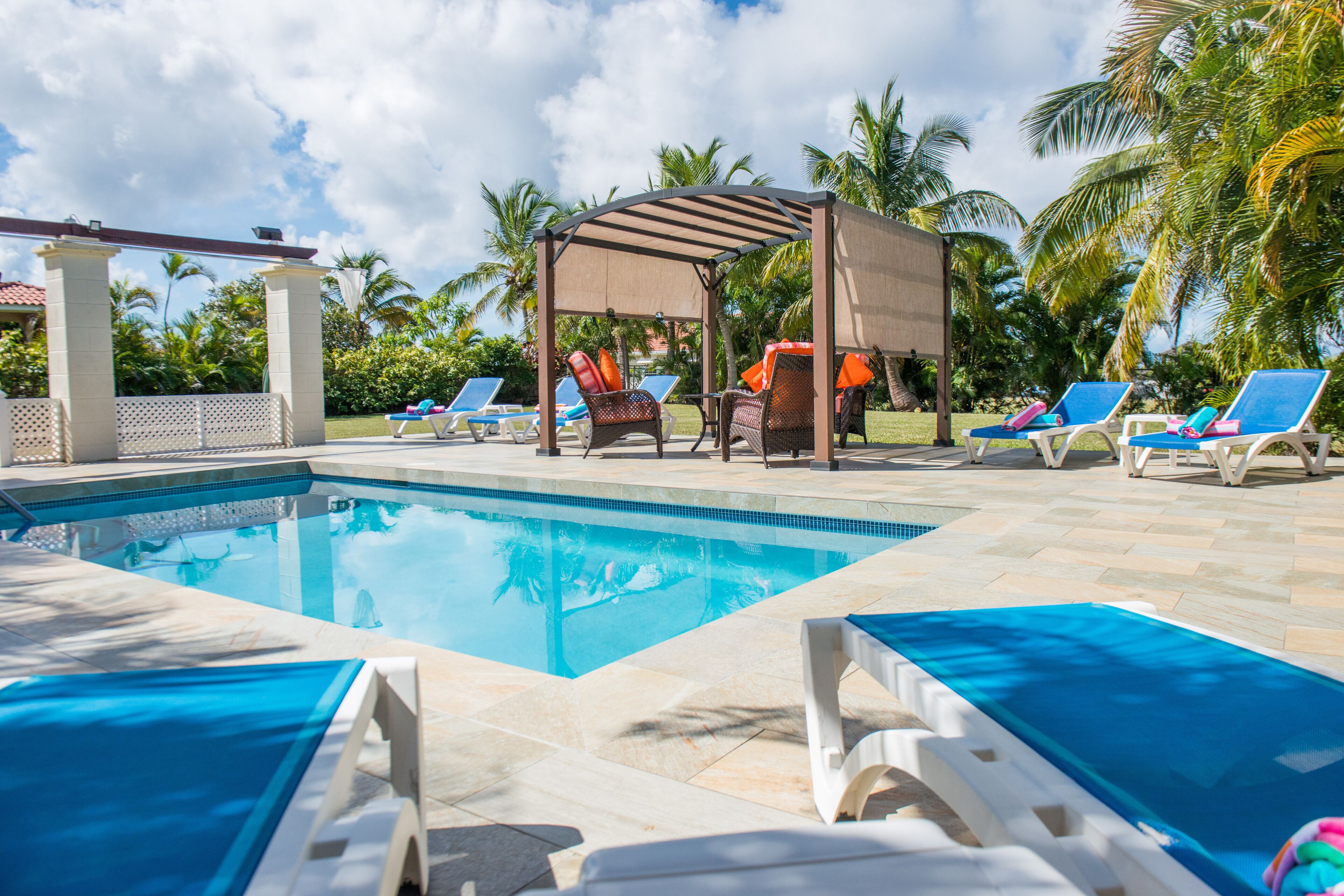 The private pool has a stone deck, sun loungers, and a shade canopy.
