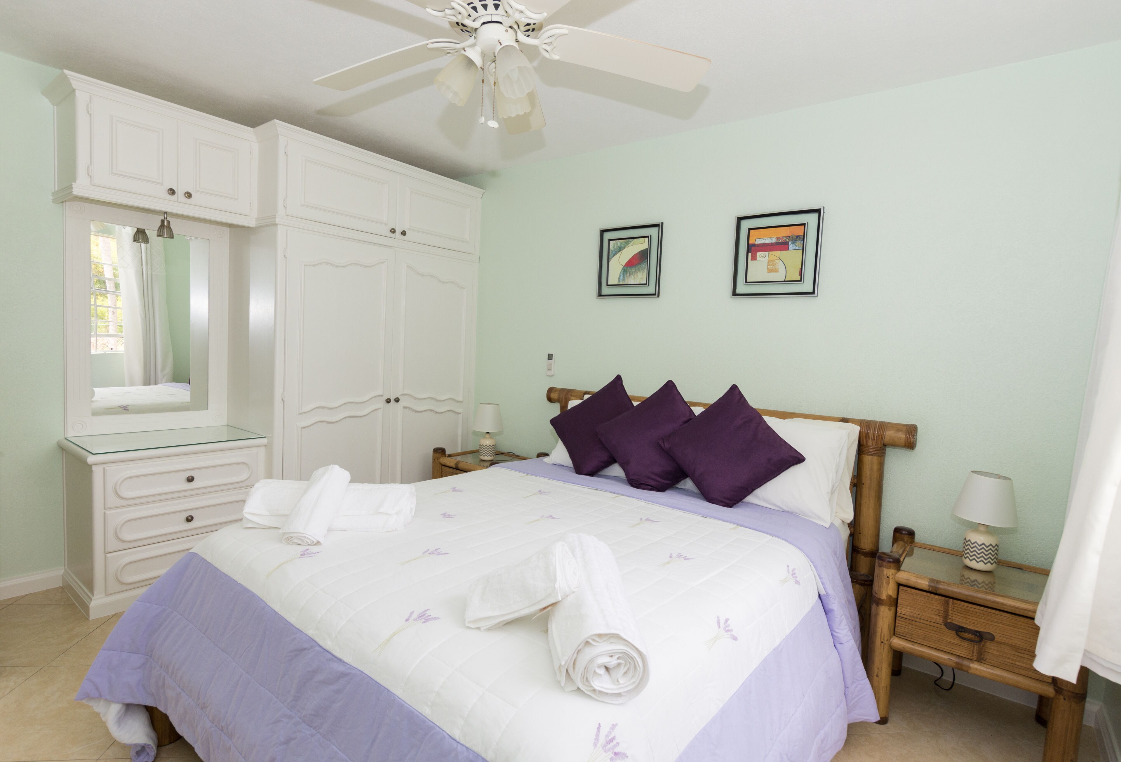 The bedroom has a double bed, a white wardrobe, and a ceiling fan.