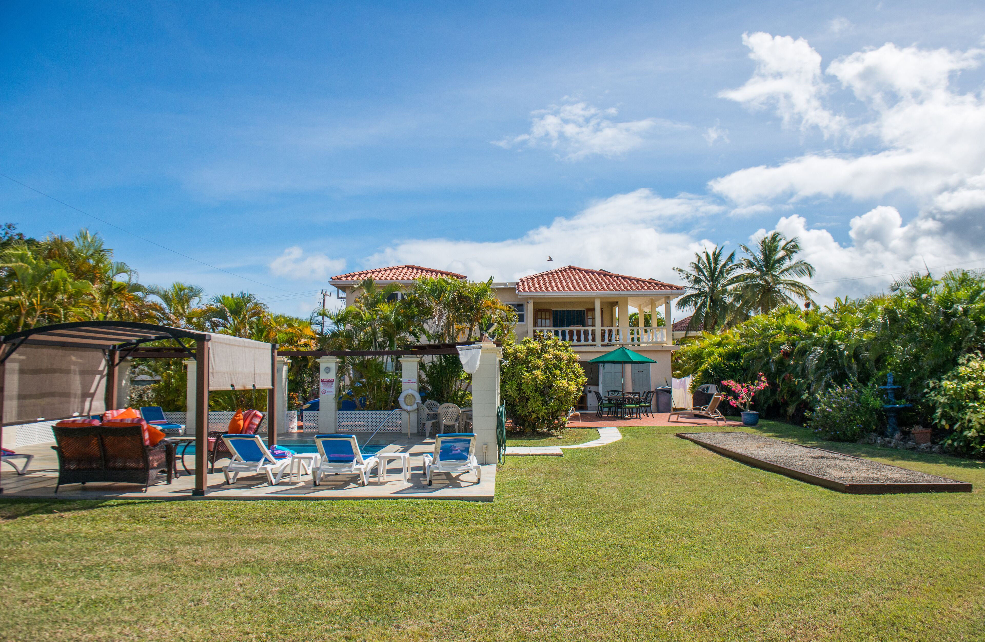 The lawn leads to the pool area and the two-story villa.