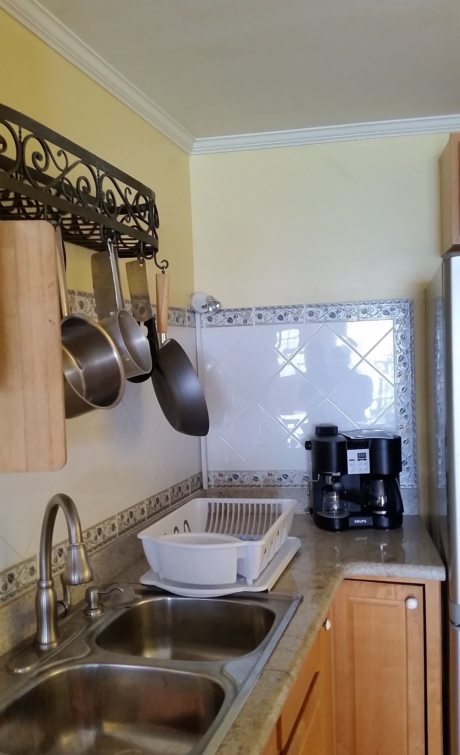 The kitchen sink, with pans on a rack and a coffee machine on the counter.