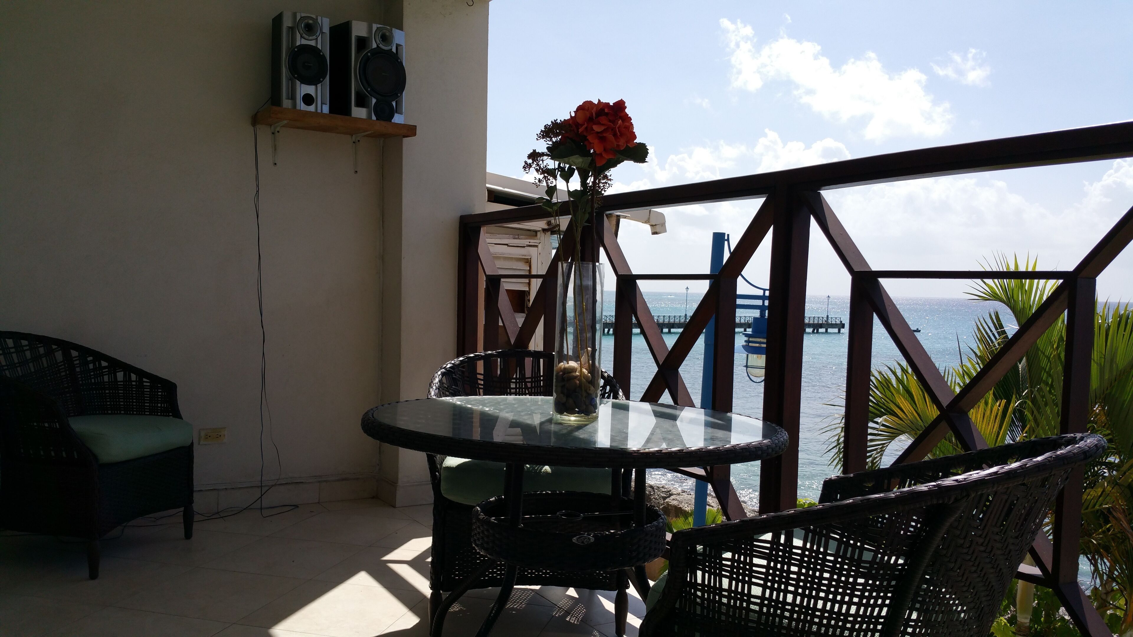 The balcony with a table and chairs, with a view of the pier.