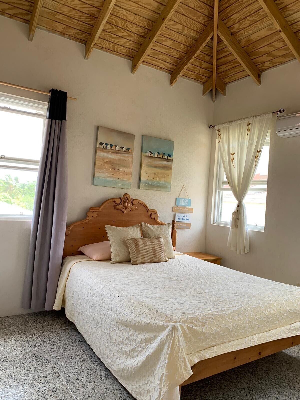 A bedroom with a double bed and a wood ceiling.