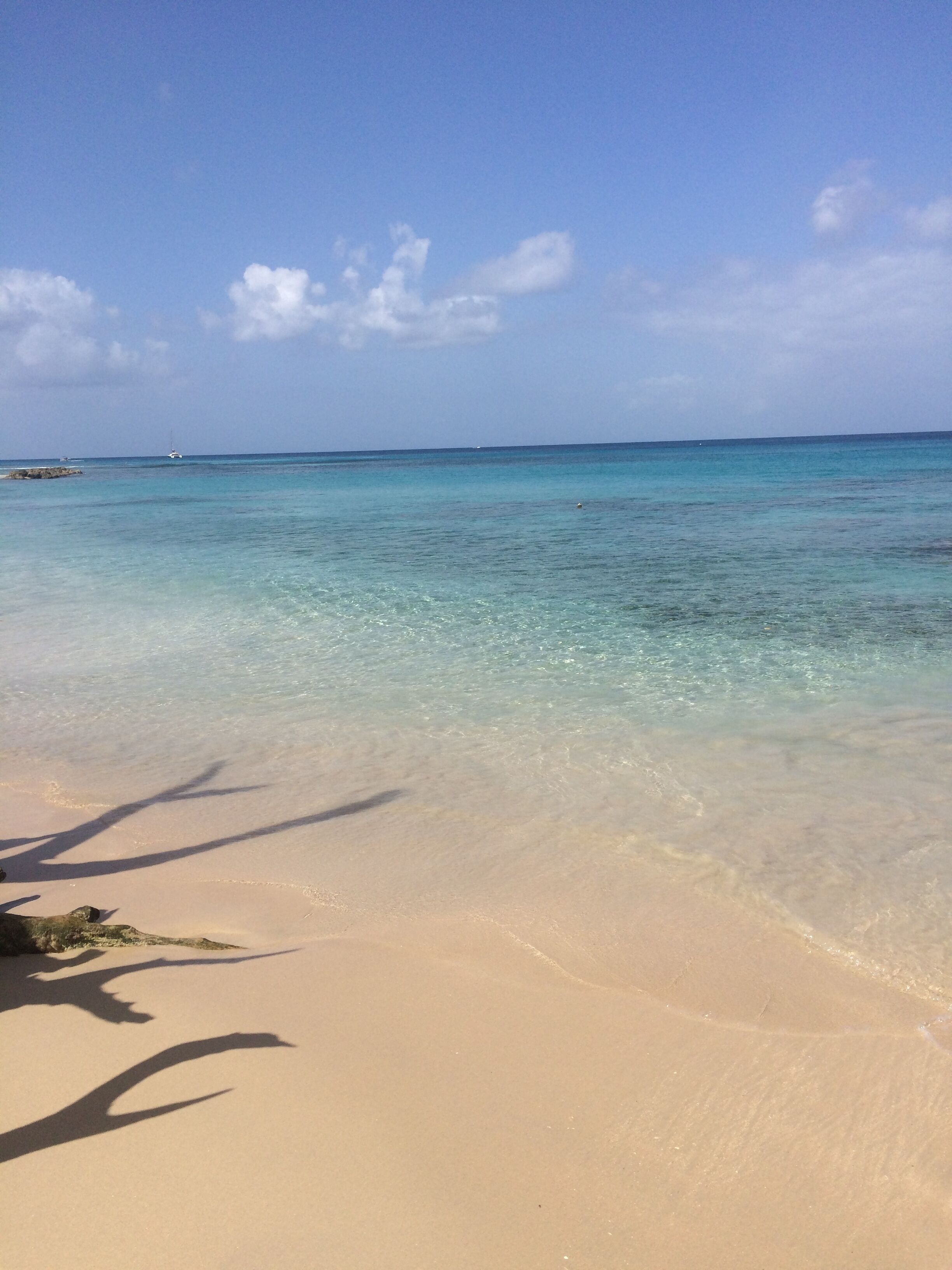 A beach with pale sand and clear water.