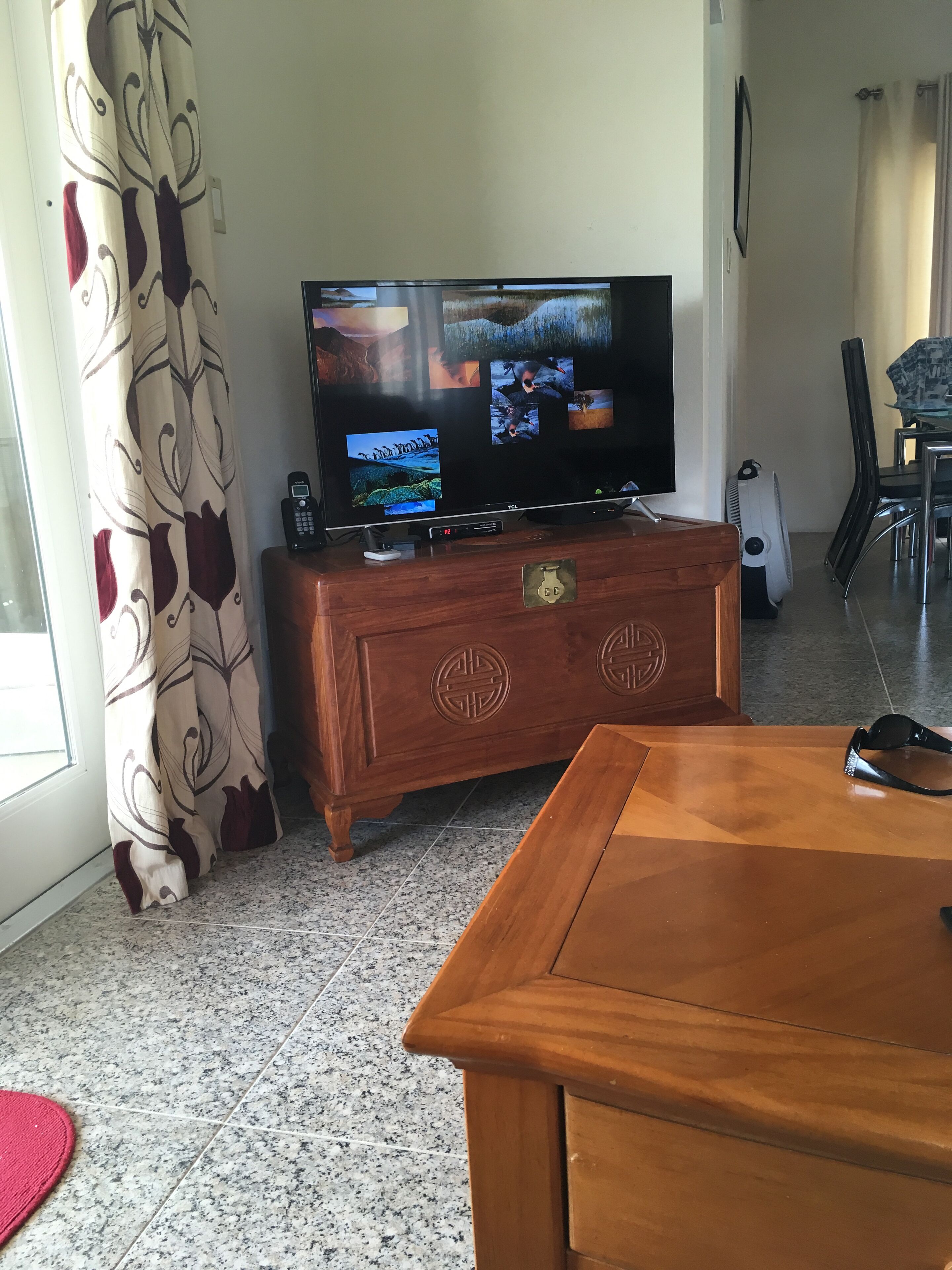 A living room with a television on a wood chest.