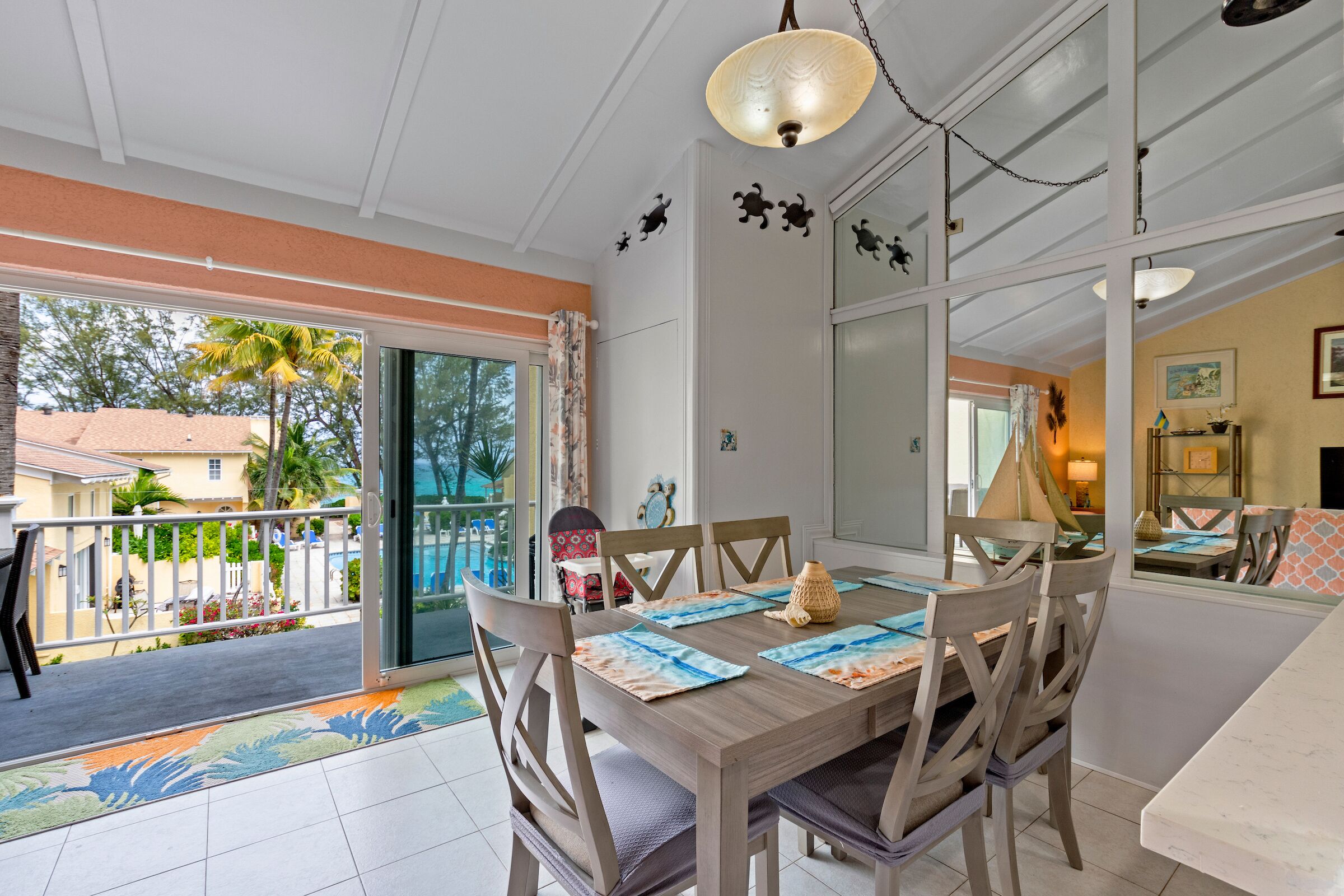 The dining area with a sliding door to the balcony and a view of the pool.