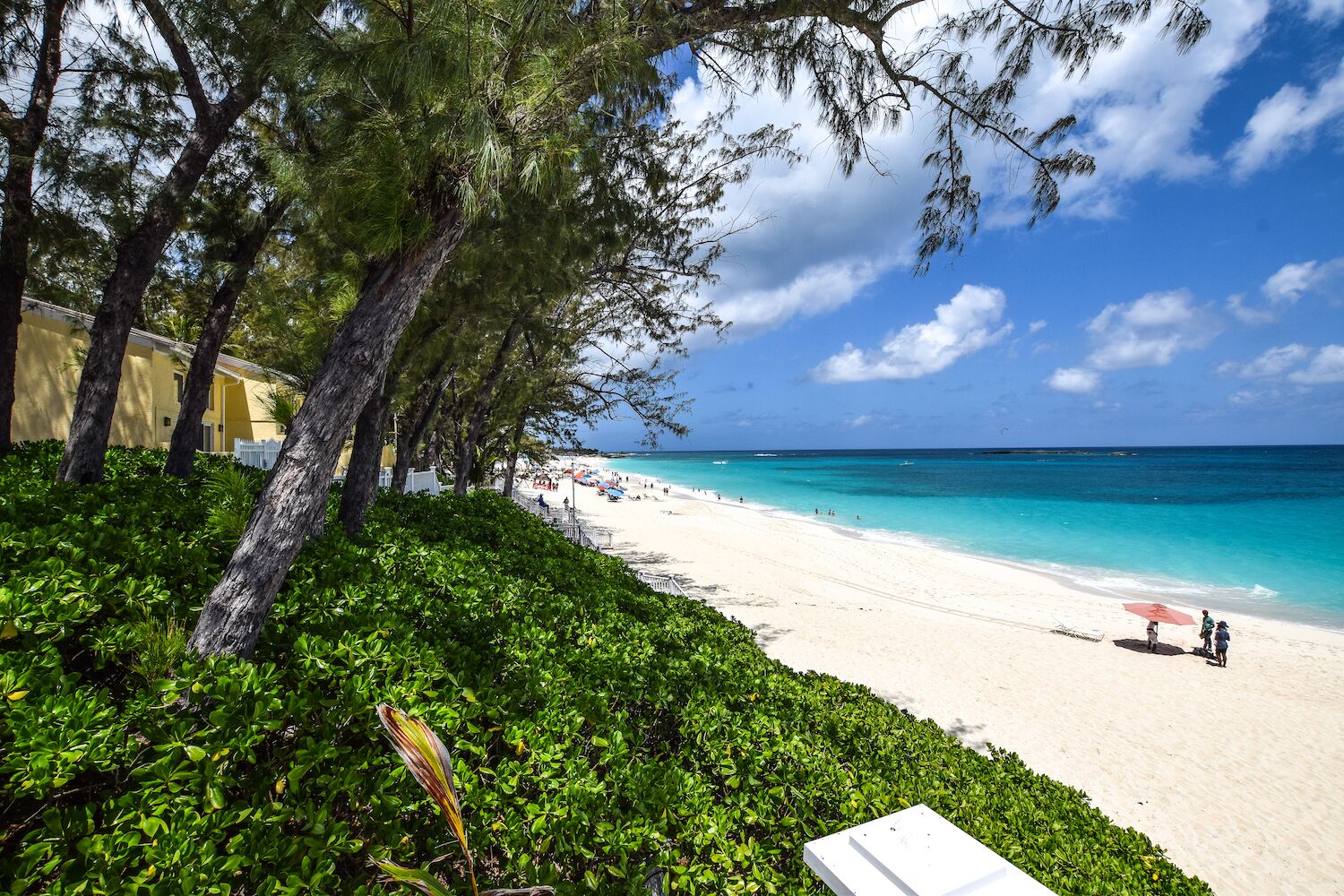 The beach with white sand next to the resort buildings.