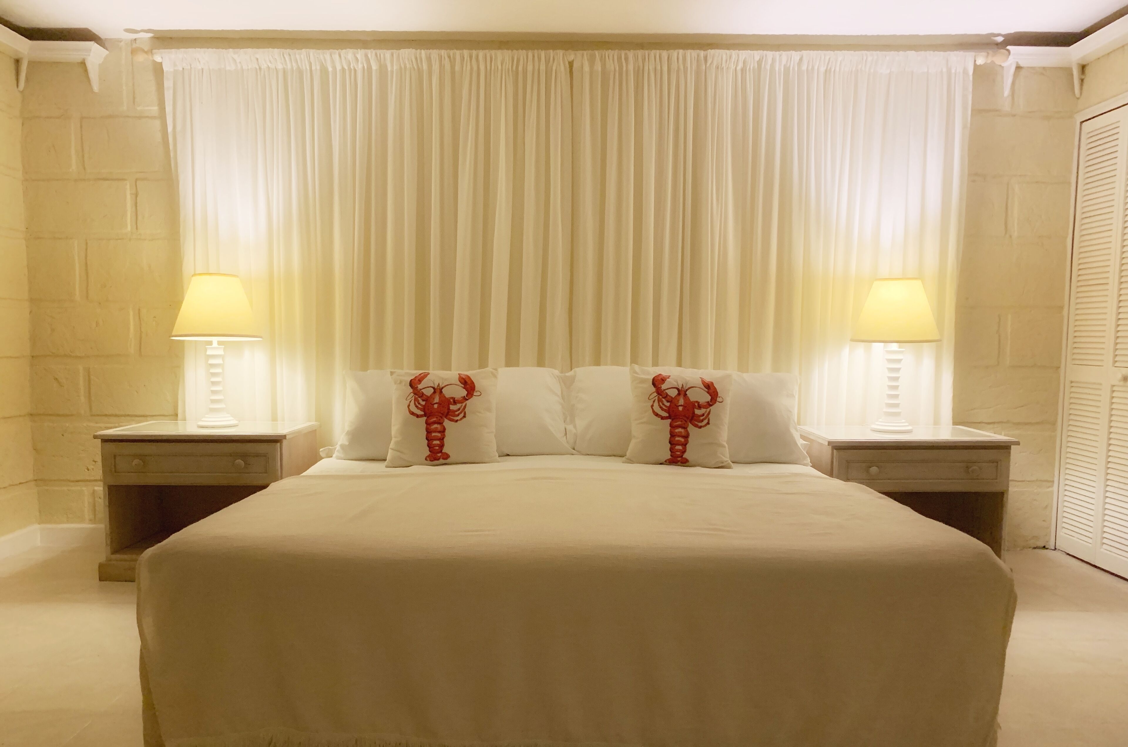 A bedroom with a wide bed and bedside lamps.