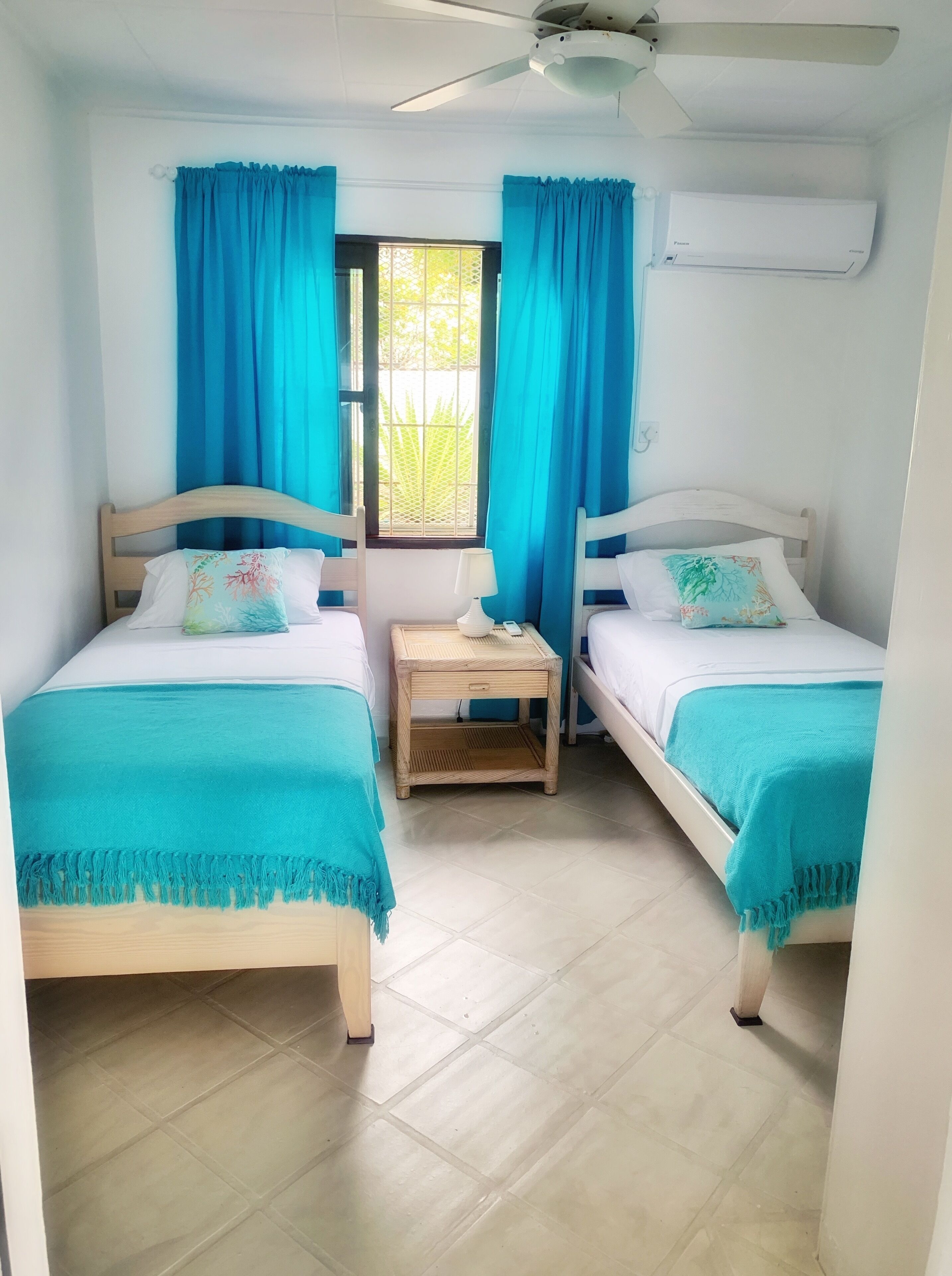 A bedroom with two single beds and a bedside table.