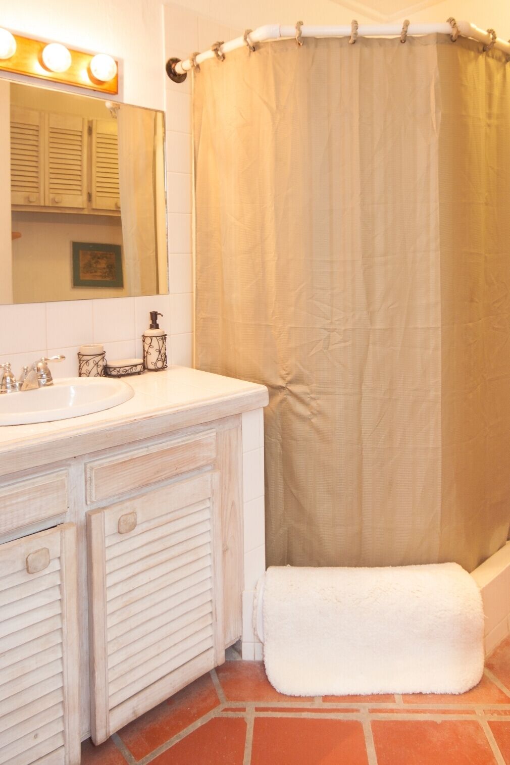 A bathroom with a corner shower and a sink.