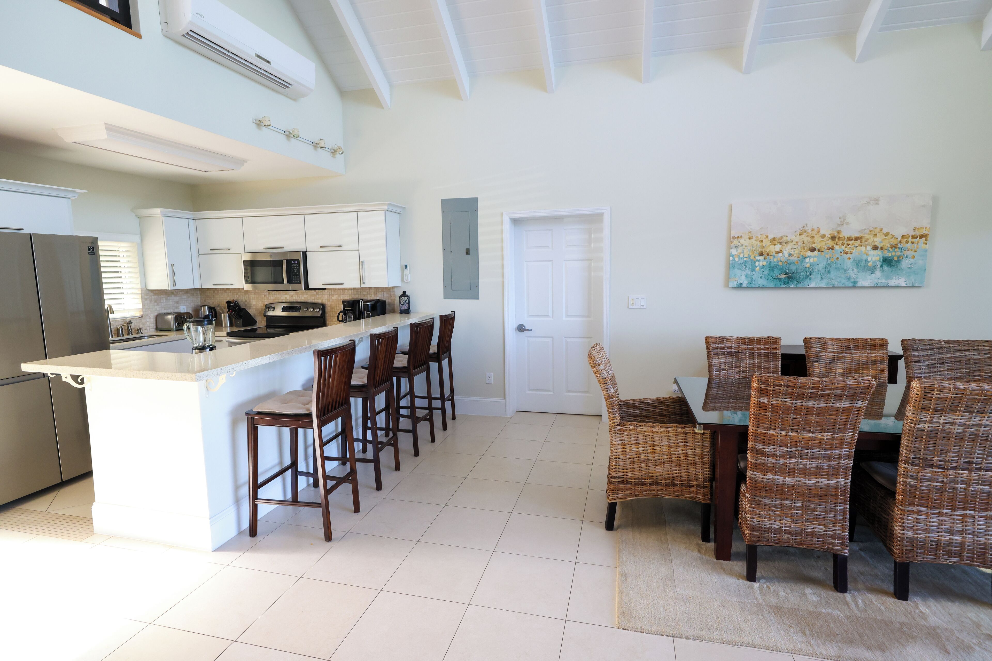 The kitchen with a bar counter and the wicker dining chairs.