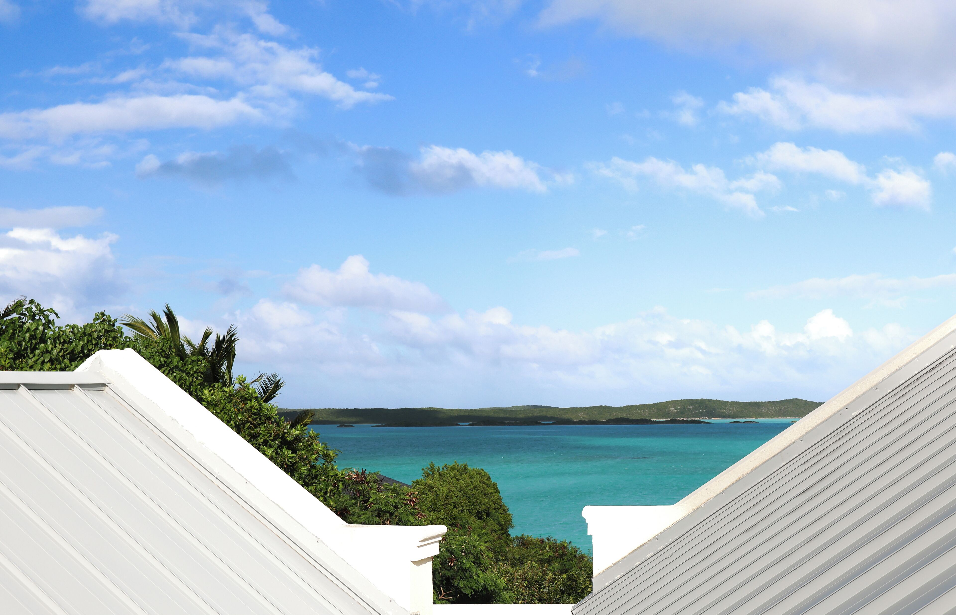 A view of turquoise water and islands between two roofs.
