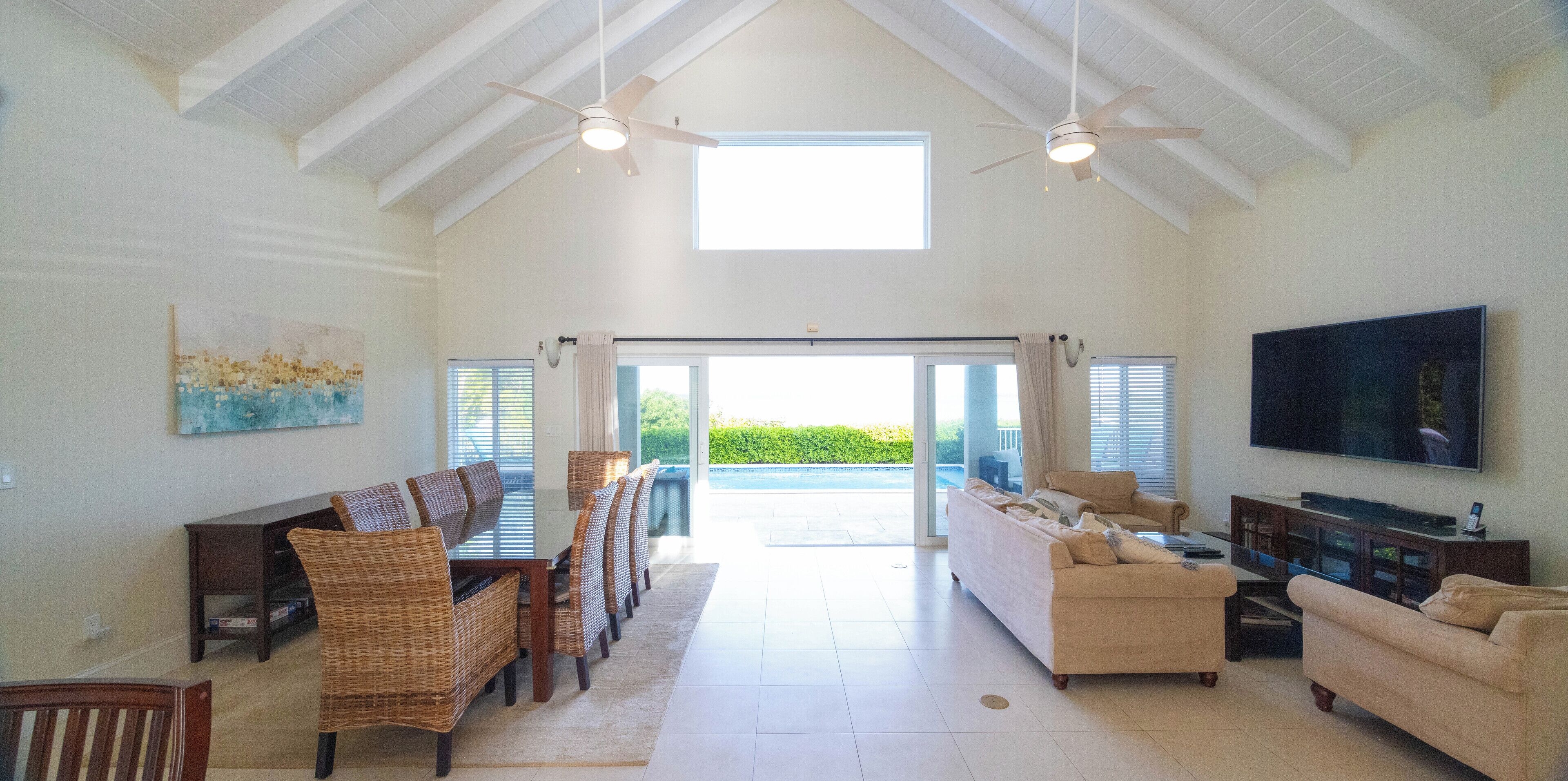 The living room with sofas and doors that open to the pool.