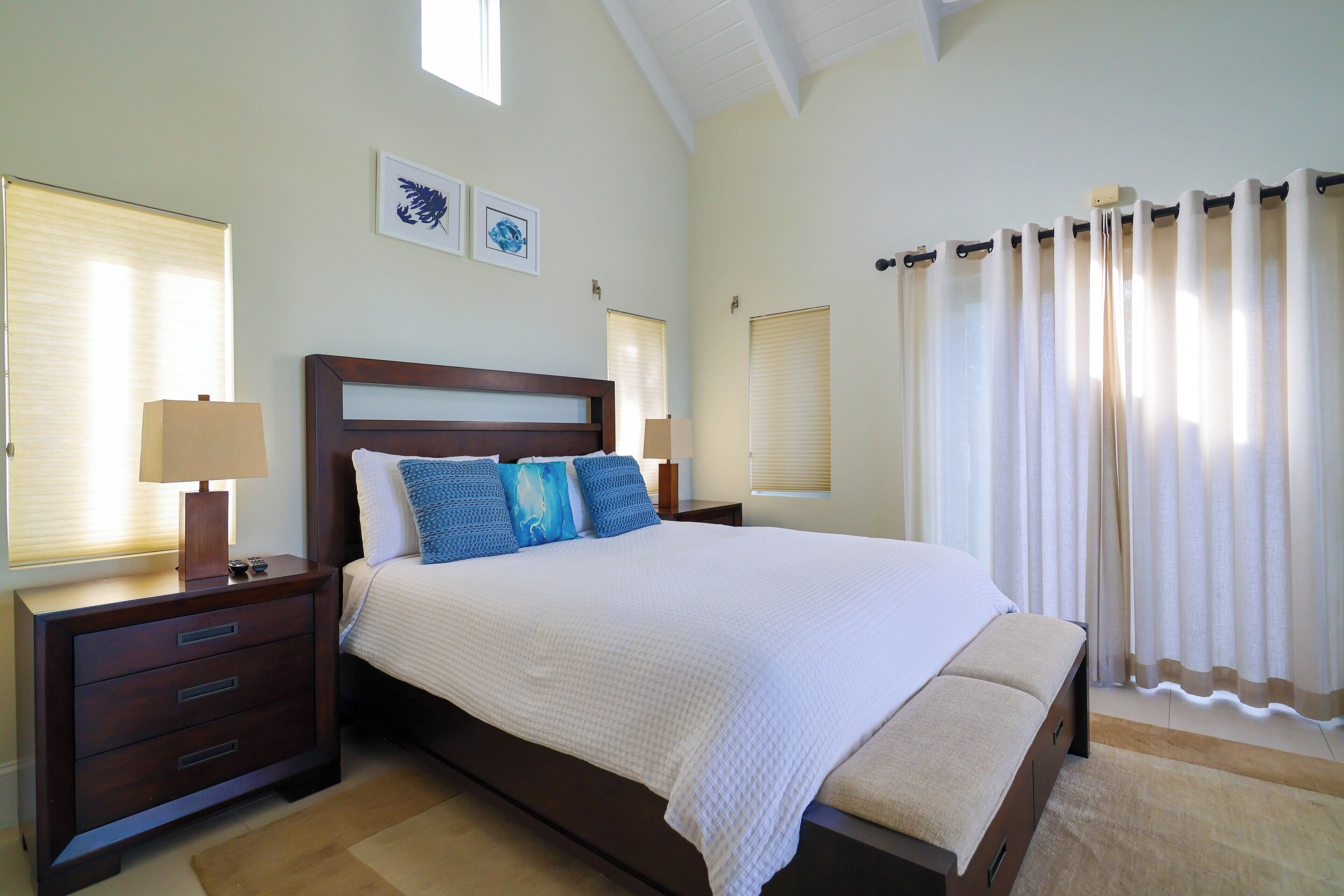 A bedroom with a dark wood bed and blue pillows.