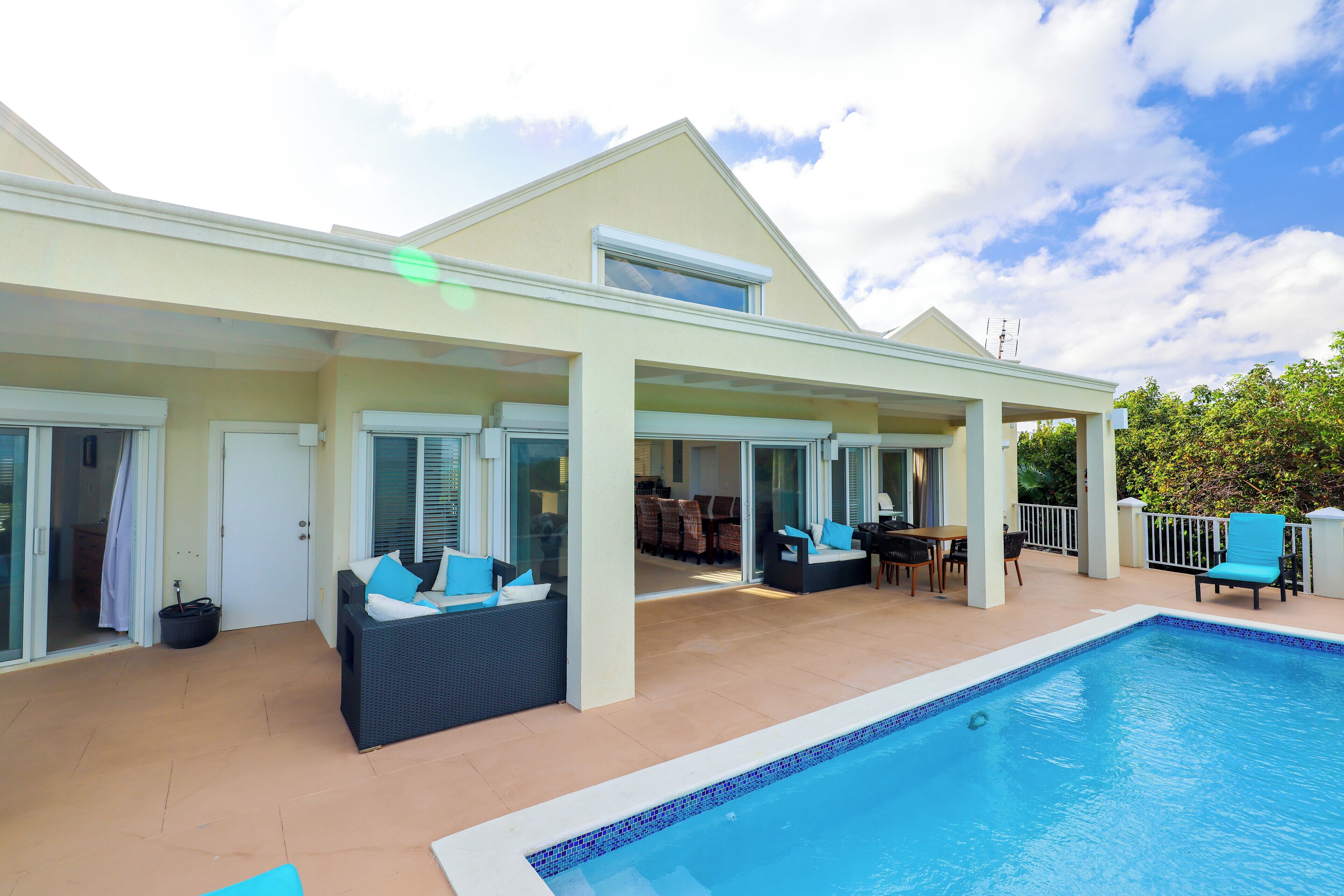 The villa with a covered terrace at the side of the pool.