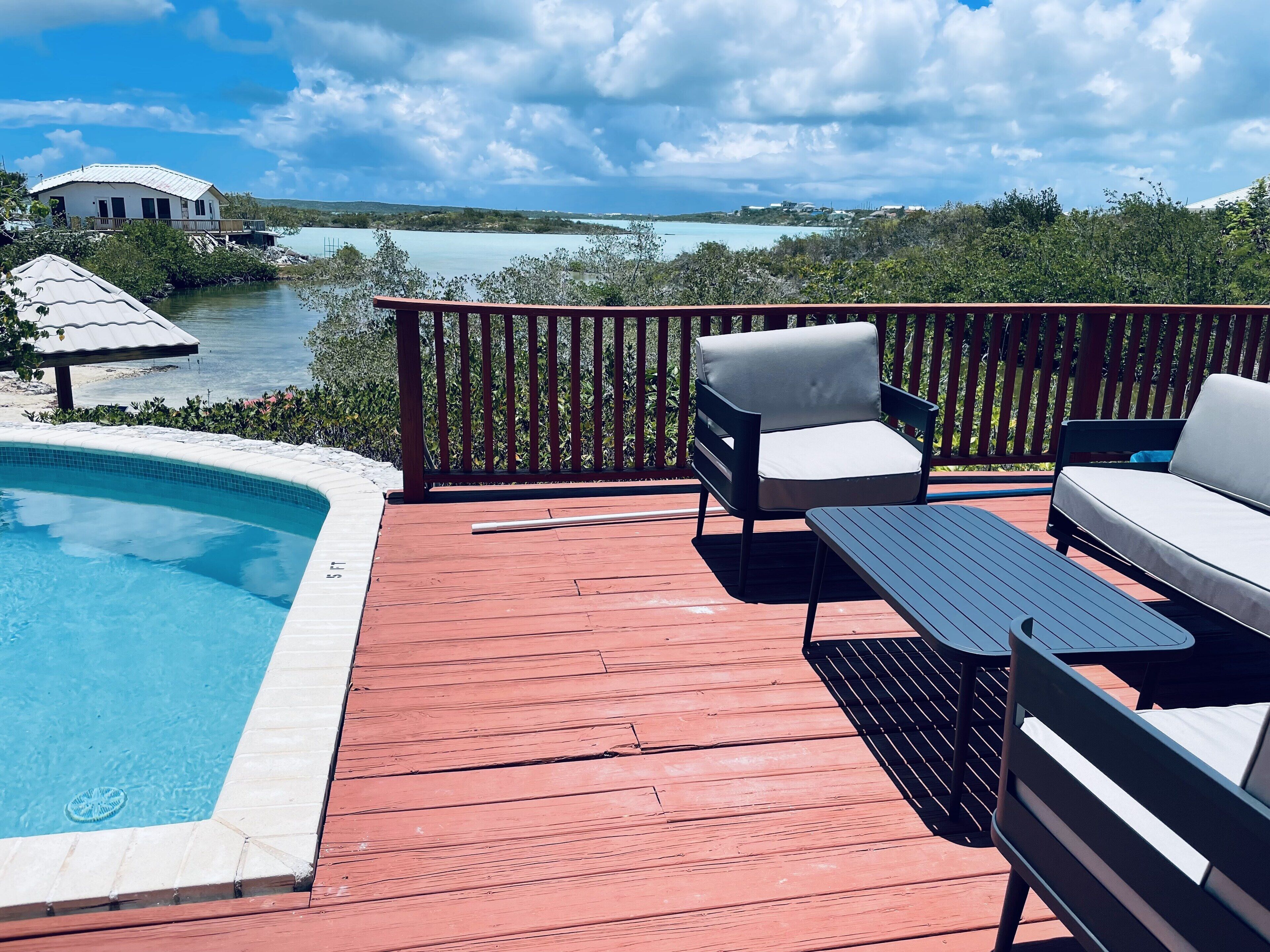 The pool and the deck rail, with a view of the turquoise water.