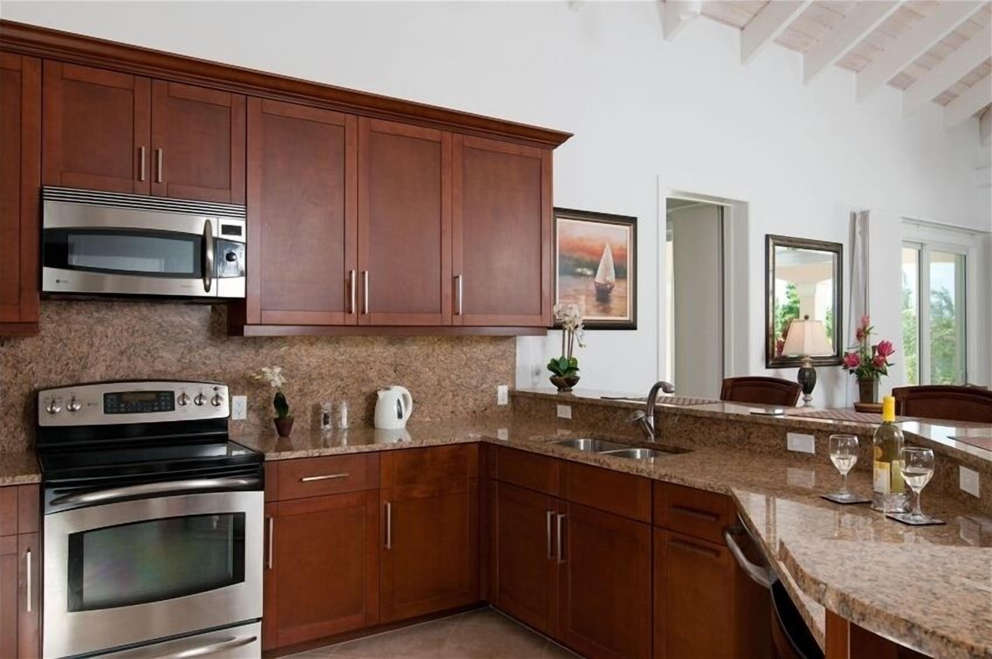 The kitchen with wood cabinets and granite counters.