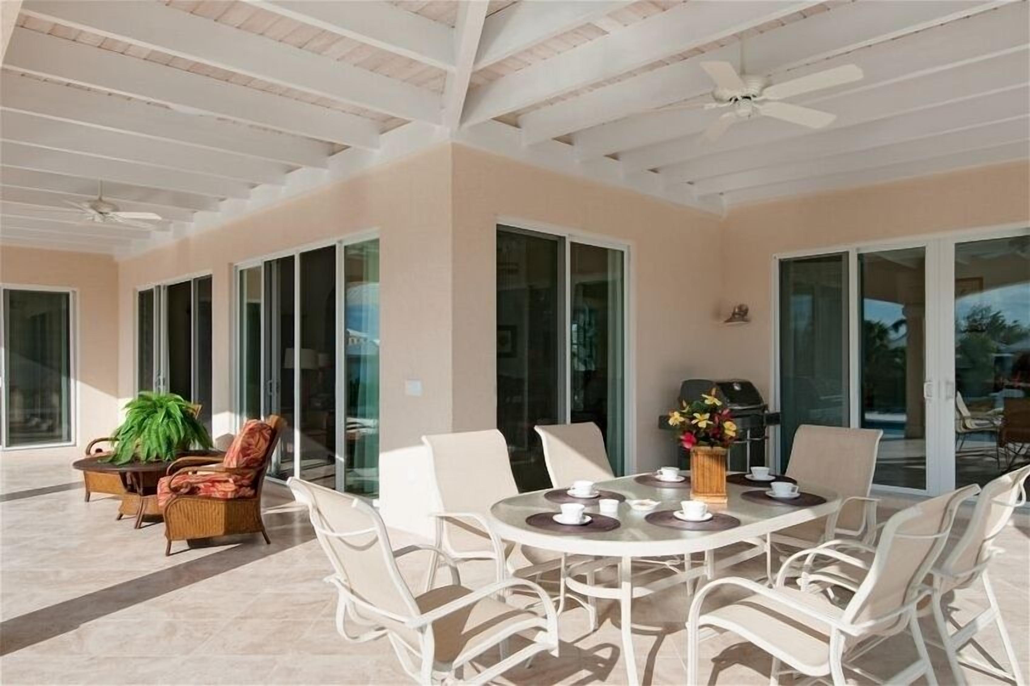 A covered veranda with an outdoor dining table and chairs.