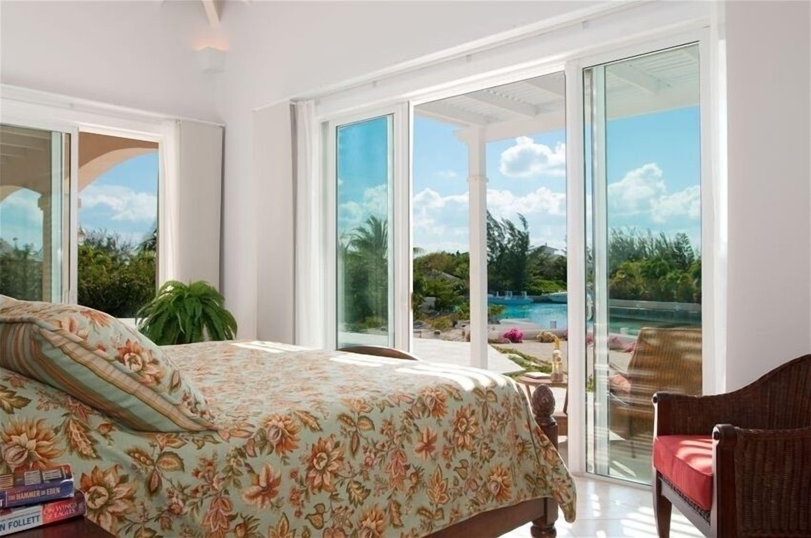 A bedroom with sliding glass doors and a view of the pool.