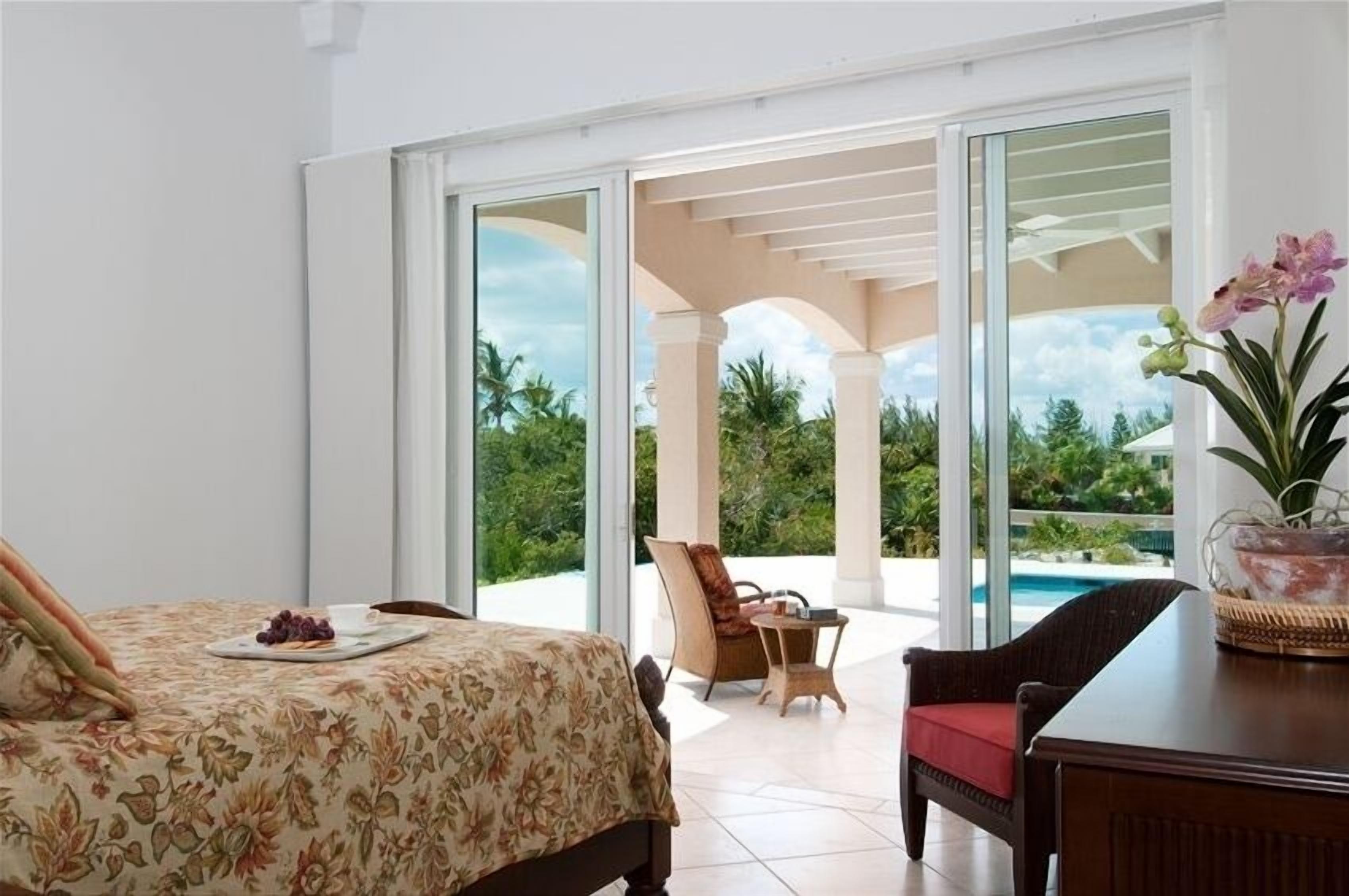 A bedroom with doors that open to the covered terrace.