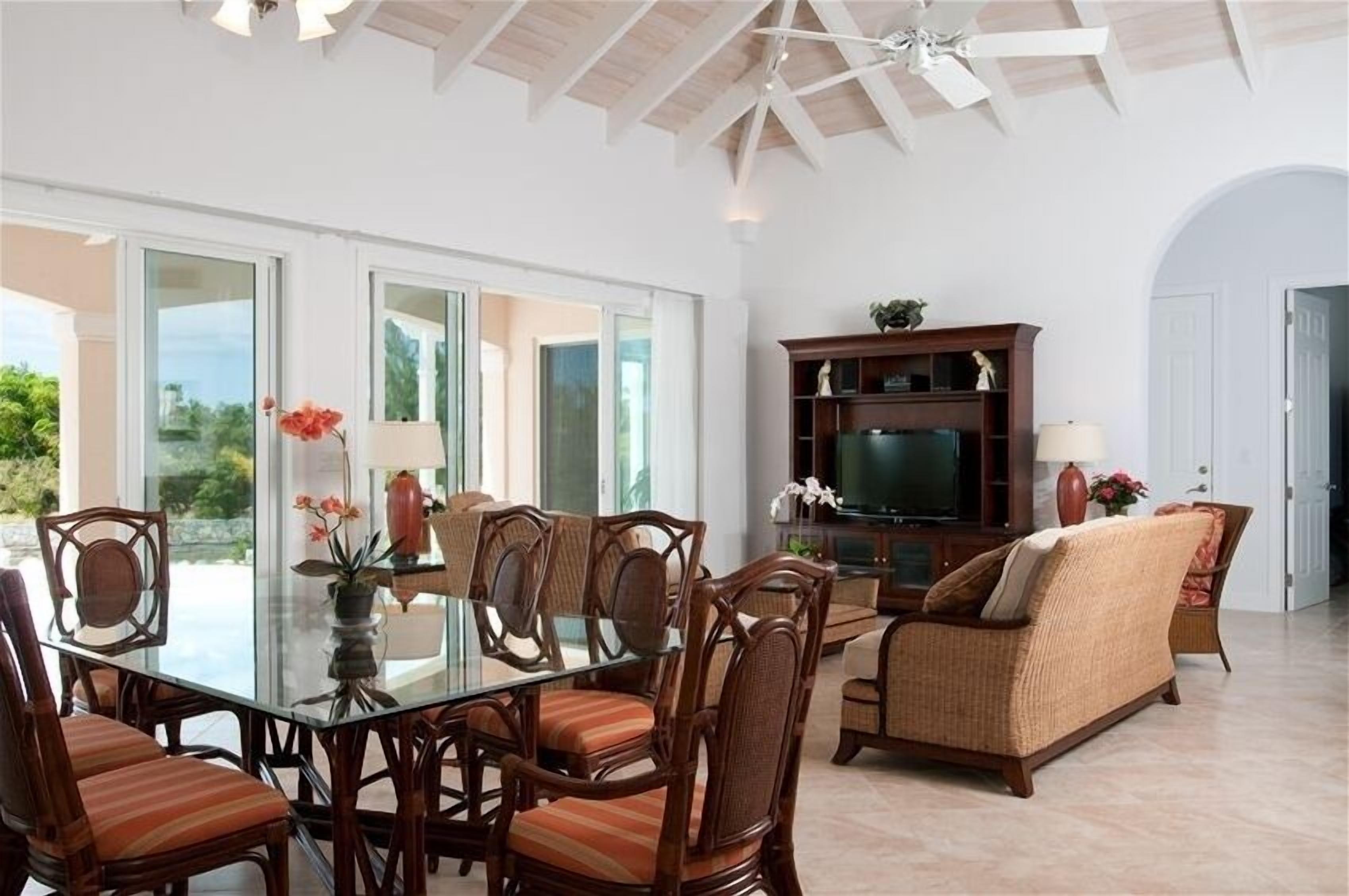 The dining area with a glass table and the living room.
